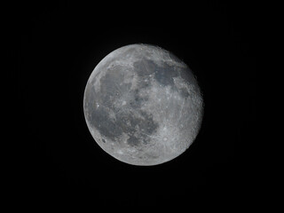 Fototapeta premium A detailed view of the Moon just before the full phase, with its craters and surface patterns clearly visible against the night sky.