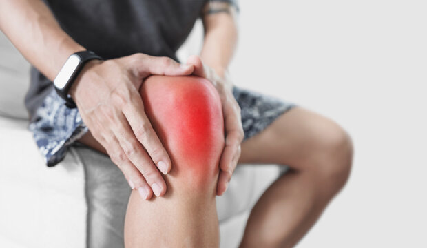 Joint pain, Arthritis and tendon problems. a man touching damaged knee, isolated on white background