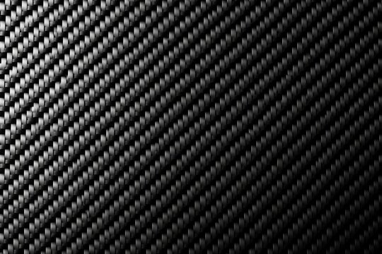 Carbon fiber pattern displaying diagonal weave on dark surface