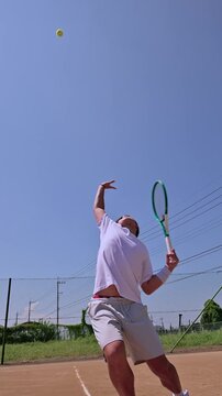 晴天のクレーコートで4k撮影されたテニス選手の迫力あるサーブ前進フォーム