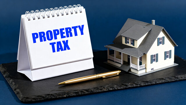 Property tax sign next to miniature house on black platform