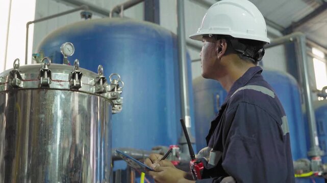 Electrical engineers are checking the maintenance systems of machinery in industrial plant. Professional engineering are taking note report data on equipment usage during work. Factory industry 