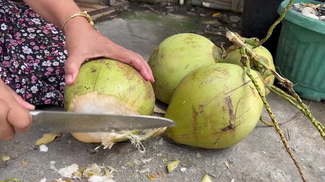 Close up of peeling organic green coconut shell