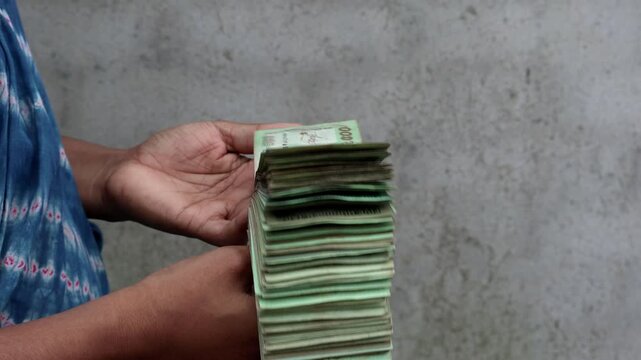 Woman Hands Displaying and Flipping Bundle of 500 Bangladeshi Taka Notes - Microfinance, Cash Flow, and Economy Concept