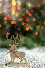 Wooden reindeer decoration with colorful bokeh vertical composition © Sarolta Nagy