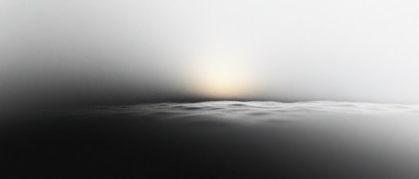 Misty monochrome seascape with faint sun over calm rippling water, minimal horizon and soft fog, serene and mysterious atmosphere