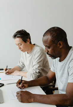 Collaboration and creative teamwork, diverse men sketching ideas on paper in a modern office for design brainstorming and professional development project