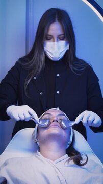 Aesthetician performing cryotherapy facial massage on client with cryo sticks.