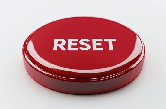 Glossy red round reset button with white lettering on a clean white surface conveying urgency and fresh start