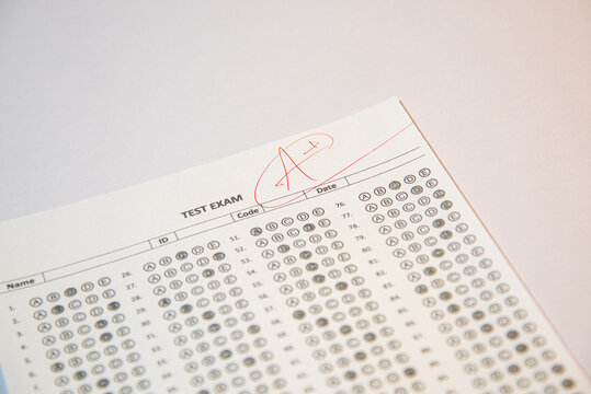 Education and assessment concept, teacher grading student exam with top mark.