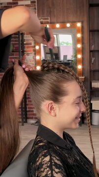 Teenage girl gets a braided ponytail hairstyle at a hair salon, professional hairstyling, youthful fashion and elegant beauty transformation.