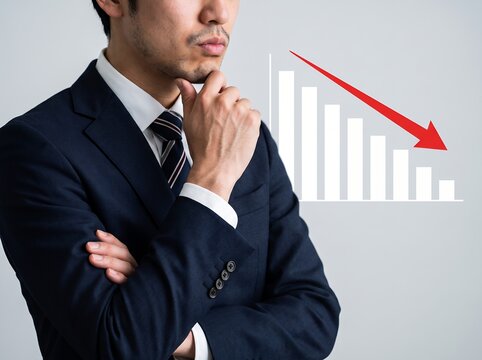 経済下落による業績不振に悩み考えるビジネスマンの深刻な表情
