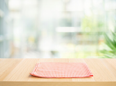 Selective focus.Fabric cloth or placemat on wood table top on big glass wall