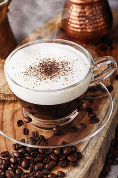 Cappuccino is an espresso-based coffee drink and steamed milk foam made from coffee in a transparent glass cup. Hot coffee with steam.