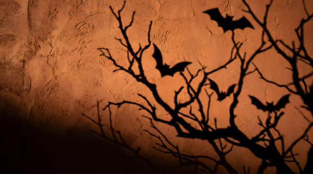 Spooky Halloween Silhouette of Flying Bats and Bare Tree Branches Against Orange Textured Wall