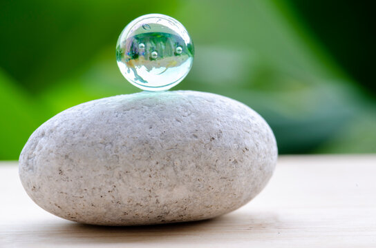 Marble on top of zen stone representing balance and calmness, with customizable space for text.