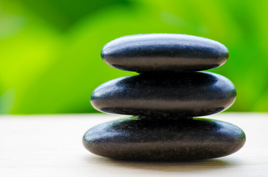 Closeup of black zen stones symbolizing balance and meditation, with customizable space for text.
