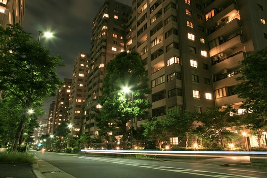 煌々と明かりが灯る夜の集合住宅群と光の軌跡