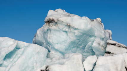 Close-up view of icebergs from Vatnajokull glacier drifting across Jokulsarlon lagoon, Iceland, highlighting beautiful ice textures and abstract shapes in summer landscape. © Asanee