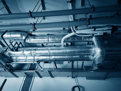 Ceiling duct network. Complex duct arrangement with service hatches and clamps visible