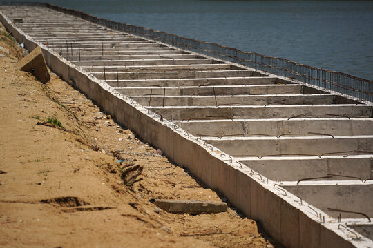Building process city levee. Exposed foundation rebar grid at site, standing formwork and concrete footings