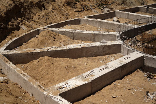 Building process city levee. Exposed foundation rebar grid at site, standing formwork and concrete footings