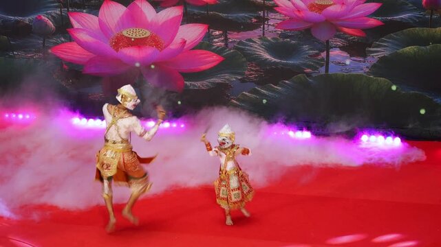 Senior Khon actor supporting a child performer in a dramatic flying battle pose of Hanuman and his son  Matchanu