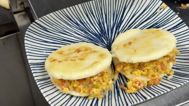 Chef preparing traditional venezuelan arepas with scrambled eggs