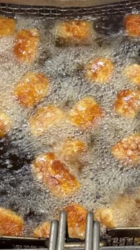 Crispy pork rinds frying in hot boiling oil