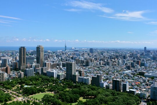 福岡市街を見下ろす高層ビル群と公園そして青い空と海