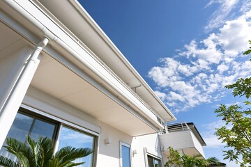 Obraz premium 清潔感あふれる白い戸建て住宅と晴れ渡る青空の美しい外観