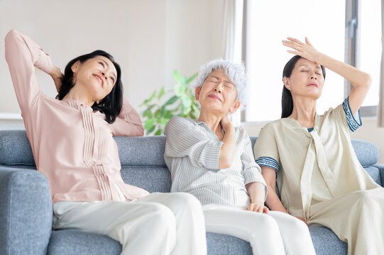 ソファに座り体調不良や疲労に悩む中高年の女性達