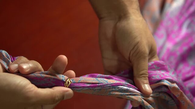 Silk Fabric Passing Through a Metal Ring During Textile Production. 