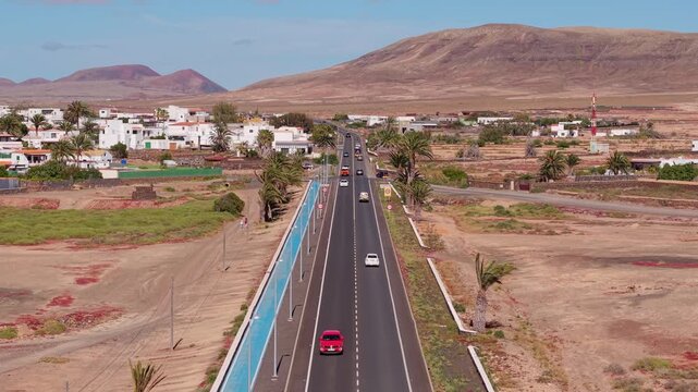 Aerial view of surroundings from El Cotillo, a coastal town located on the island of Fuerteventura, Canary Islands, Spain. Drone POV of the road leading to the El Roque village in desert.