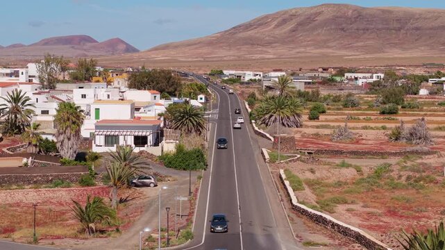 Aerial view of surroundings from El Cotillo, a coastal town located on the island of Fuerteventura, Canary Islands, Spain. Drone POV of the road leading to the El Roque village in desert.