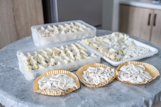 Frozen handmade dumplings and noodles are laid out on the table.
