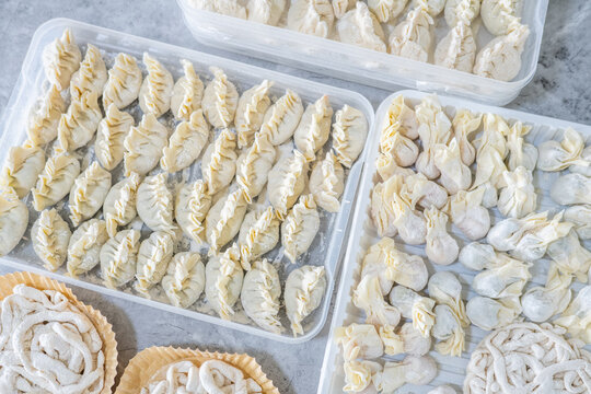 A food storage container filled with frozen handmade dumplings.