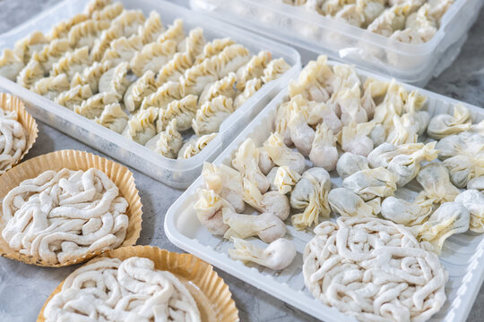 A food storage container filled with frozen handmade dumplings.