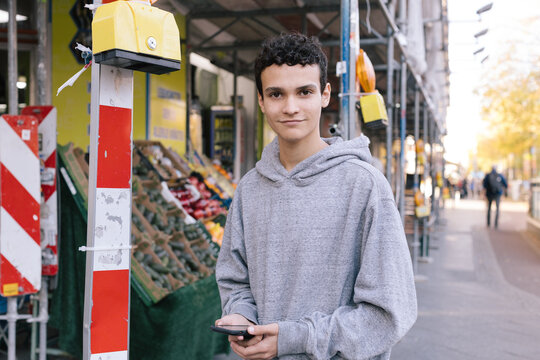 Young man with smartphone at an outdoor market
