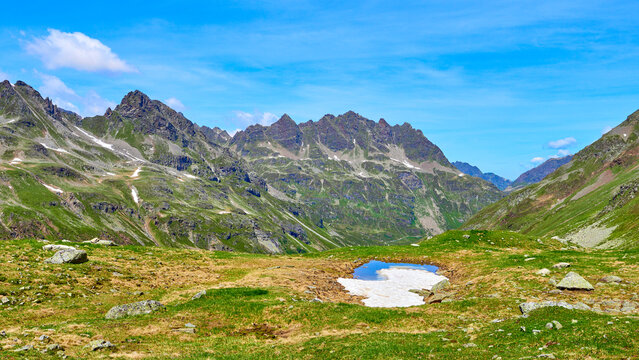 T&uuml;mpel mit letztem Schneefeld vor zerkl&uuml;fteten Alpengipfeln im Silvretta-Gebiet