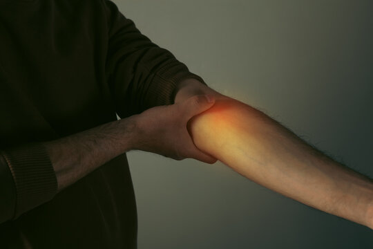 Young man suffering from pain in the elbow.