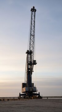 Ship to shore crane boom raised against a pale morning sky