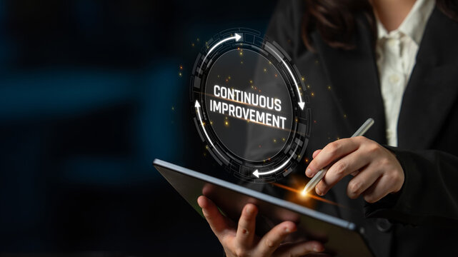 Business Professional Using Tablet for Strategies of Continuous Improvement in Modern Workspace with Futuristic Graphics and Dark Background Sigmoid