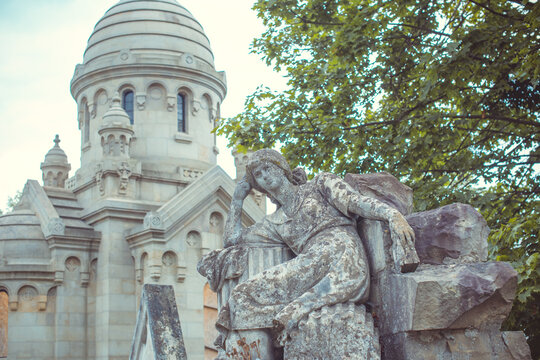 Ancient cemetery monuments featuring ornate gravestones, weathered stone sculptures and historic tombs surrounded by trees. Atmospheric old-world funerary architecture and timeless memorial details 
