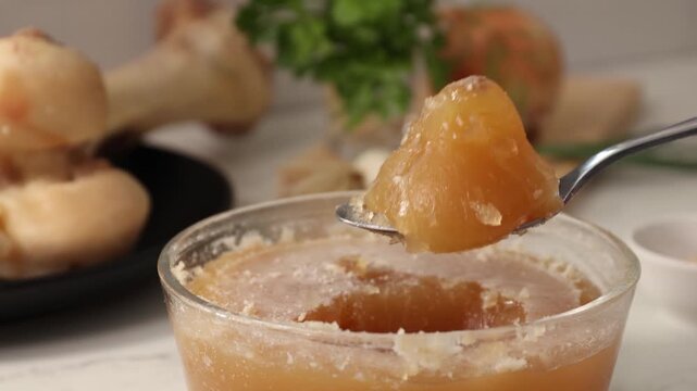 Dense, gelatinous bone broth jelly in a glass jar; collagen-rich, anti-aging broth ready to use