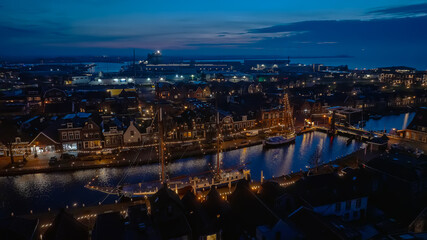 Fototapeta premium Aerial from illuminated old boats in Lemmer in Friesland the Netherlands at sunset