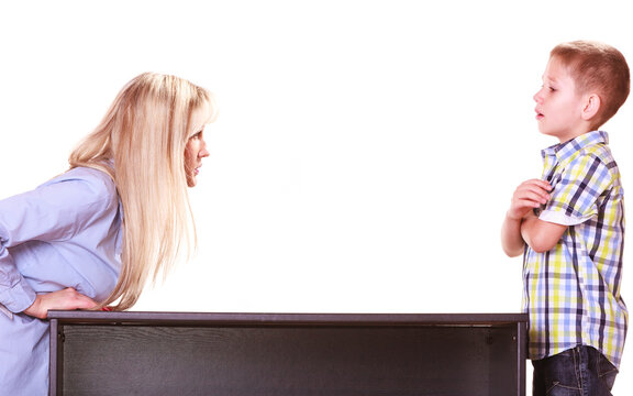 Mother and son talk and argue sit at table.