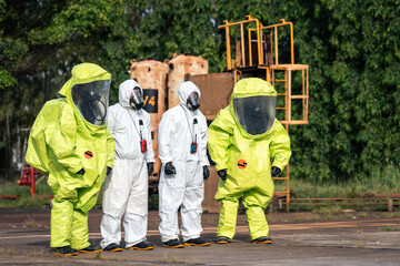 Fototapeta na wymiar Hazmat response team walking together through an industrial facility during hazardous materials emergency preparedness and workplace safety training in full protective suits