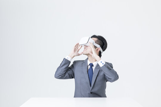 Businessman wearing virtual reality headset in minimalist office setting