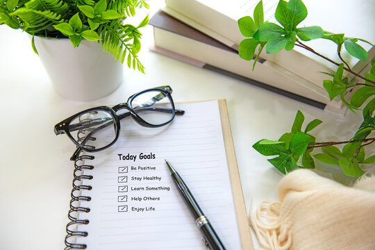 Notebook with life goals checklist on a bright workspace for personal growth and future planning with coffee.  Goal Life Wellness Concept.